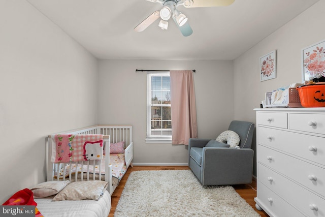 bedroom featuring ceiling fan, baseboards, and wood finished floors