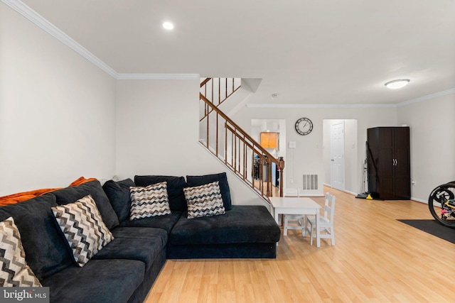 living area with visible vents, baseboards, stairway, light wood-type flooring, and ornamental molding