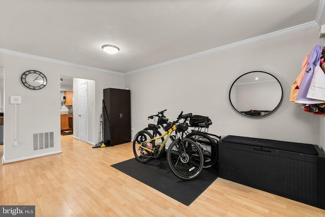 misc room with light wood-style flooring, baseboards, visible vents, and ornamental molding