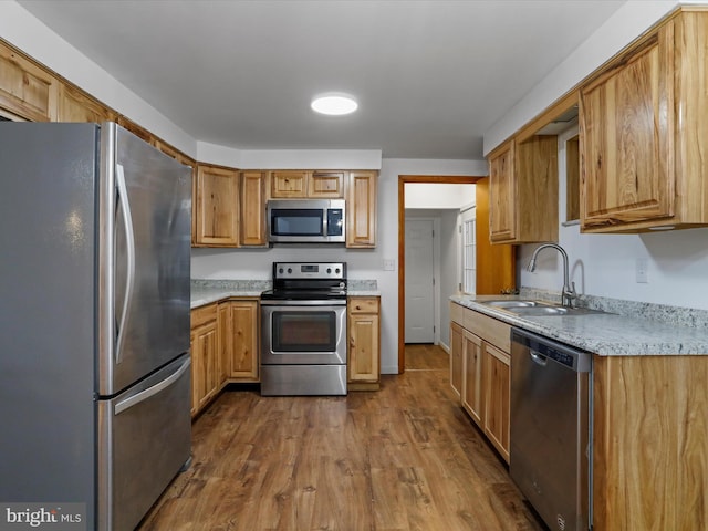 kitchen with dark wood-type flooring, light countertops, appliances with stainless steel finishes, and a sink