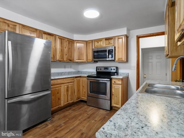 kitchen featuring a sink, light countertops, dark wood finished floors, and stainless steel appliances