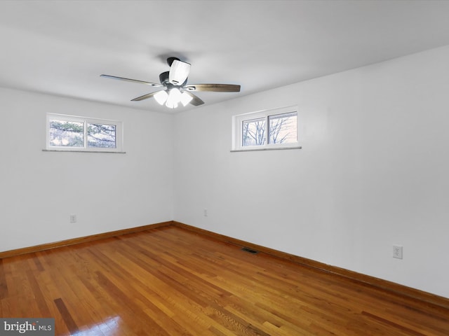 spare room with visible vents, baseboards, light wood-type flooring, and ceiling fan