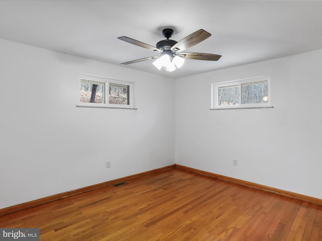 empty room featuring visible vents, ceiling fan, baseboards, and light wood-style floors