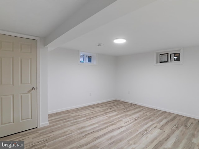 basement with baseboards and light wood-style floors