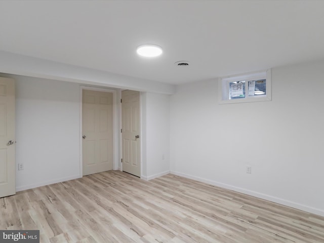 below grade area with visible vents, baseboards, and wood finished floors