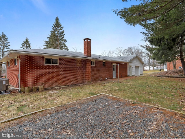 back of property with central air condition unit, brick siding, and a chimney