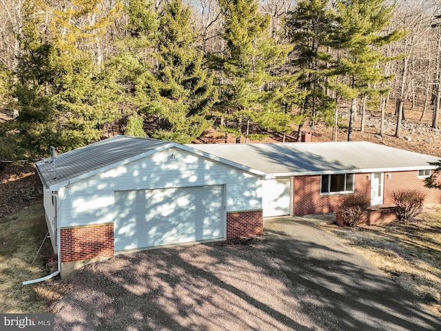 exterior space featuring brick siding, driveway, and a garage