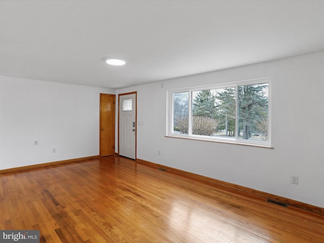 empty room featuring visible vents, baseboards, and light wood-style floors