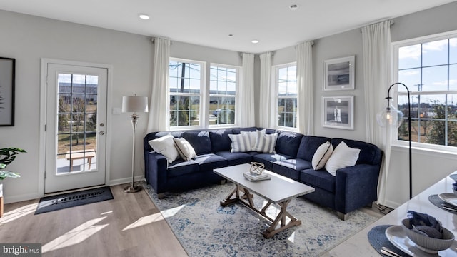 living area with recessed lighting, baseboards, and light wood-type flooring