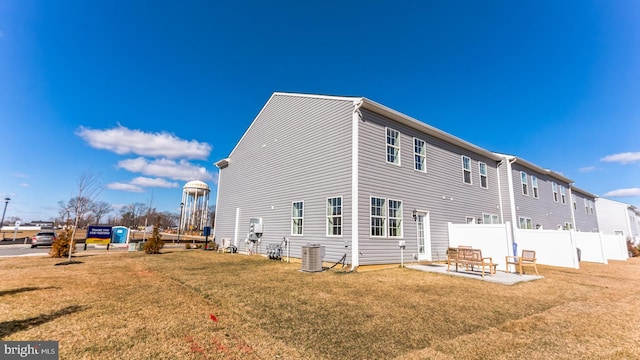 back of property featuring central air condition unit, a lawn, a patio area, and fence