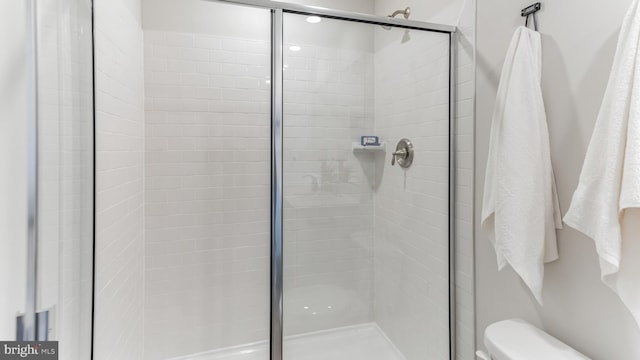 bathroom with a shower stall and toilet