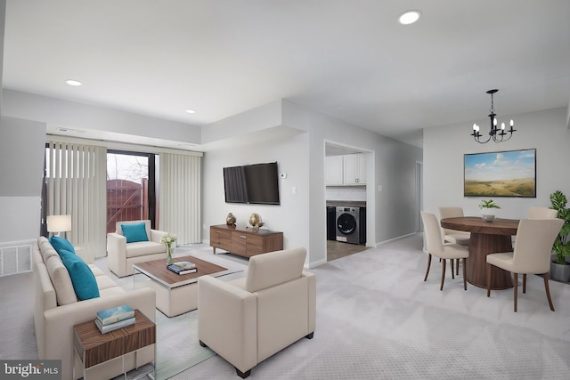 living area featuring recessed lighting, light colored carpet, washer / dryer, and a chandelier