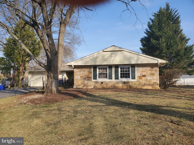 view of front of property featuring aphalt driveway, an attached garage, stone siding, and a front lawn