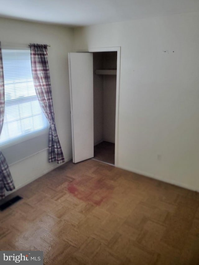 unfurnished bedroom with a closet and visible vents