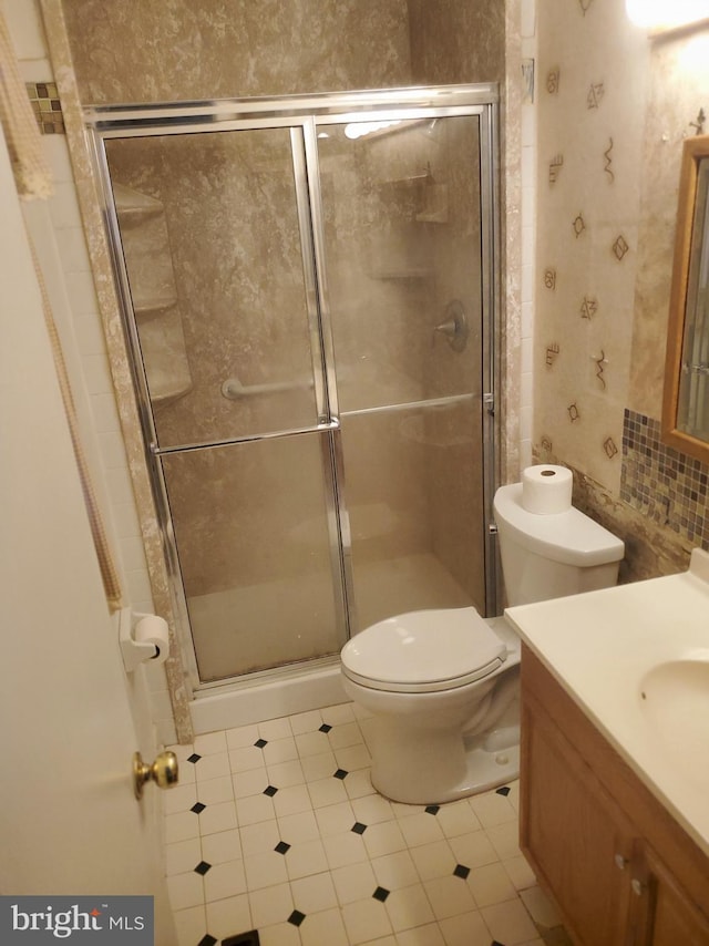 full bathroom featuring toilet, a stall shower, and vanity