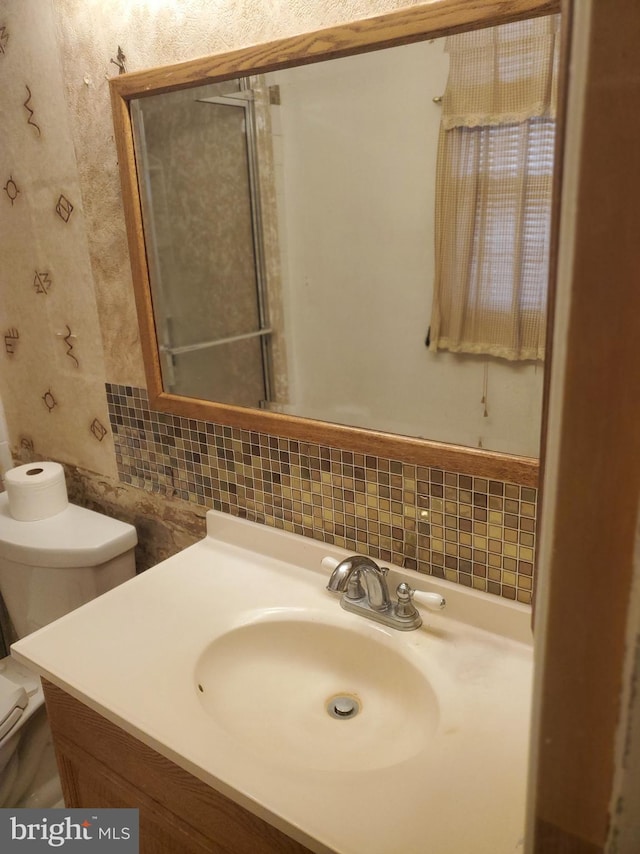 bathroom featuring vanity, decorative backsplash, toilet, and tile walls