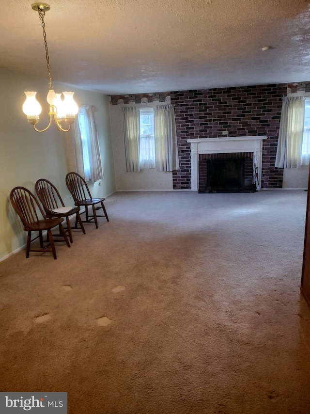 unfurnished living room featuring plenty of natural light, a textured ceiling, an inviting chandelier, and carpet floors