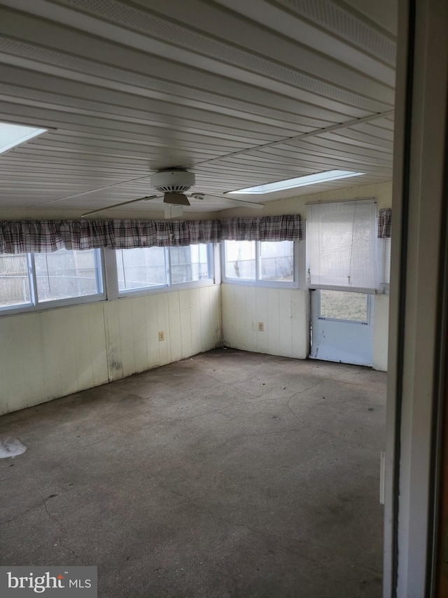 unfurnished sunroom with ceiling fan