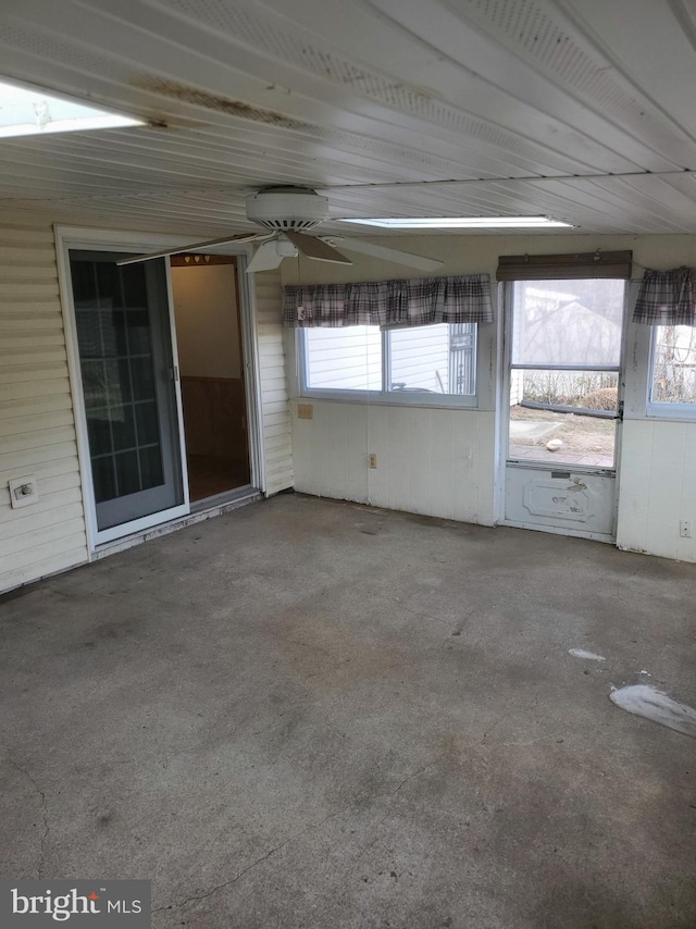 unfurnished sunroom with a ceiling fan