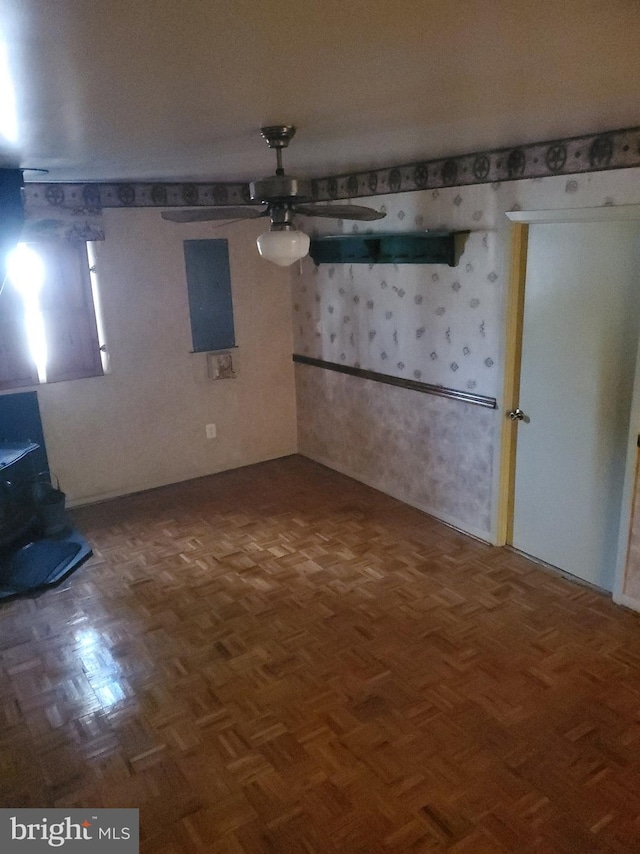 interior space with ceiling fan and a wood stove