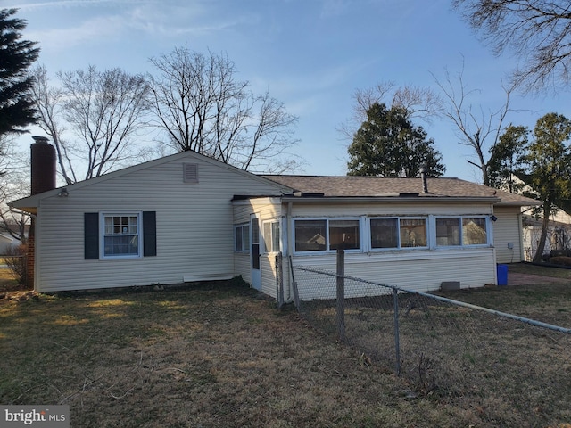 view of front of house featuring a front yard, fence, and a chimney