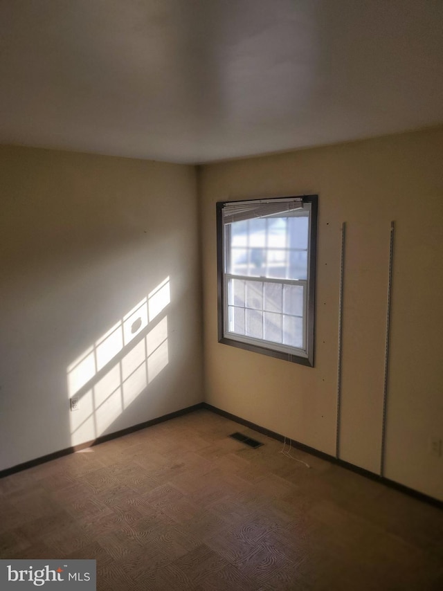 empty room featuring visible vents and baseboards