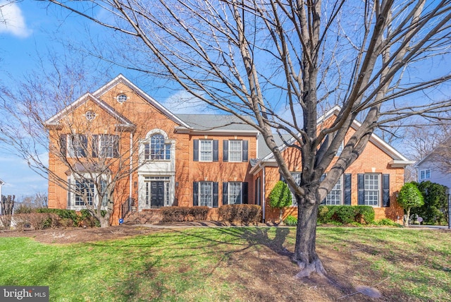 view of front of house featuring brick siding and a front lawn