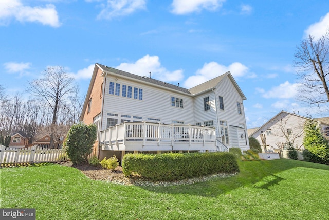 back of house with a lawn, fence, and a wooden deck