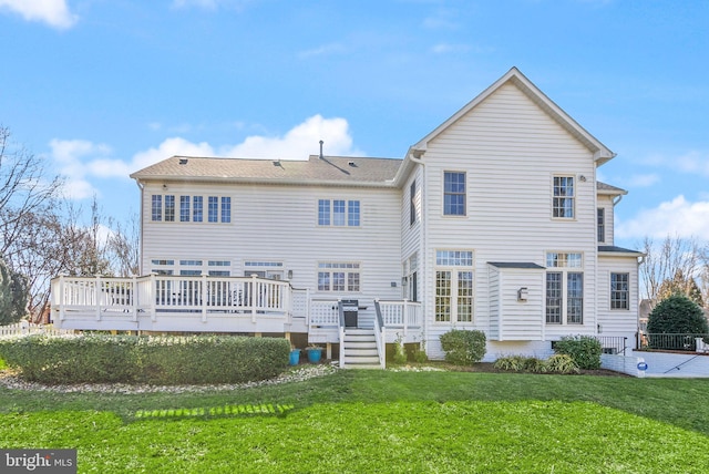 back of property with a deck, a yard, and a shingled roof