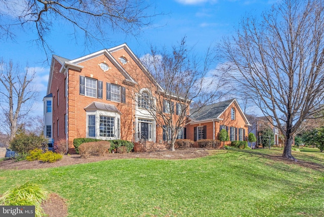 view of front of home with brick siding and a front yard