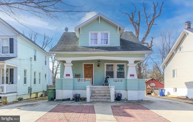 view of front of property with covered porch and a shingled roof