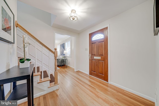 foyer featuring stairway, baseboards, and light wood-style floors