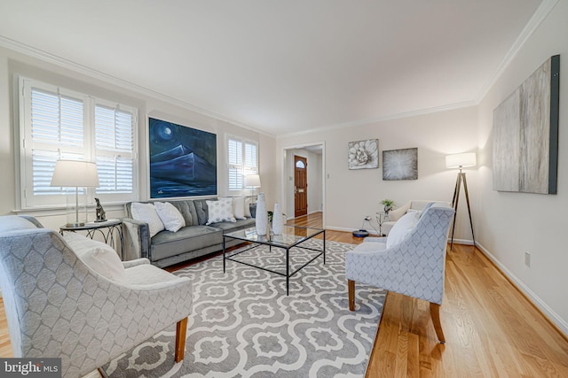 living area with light wood finished floors, baseboards, and ornamental molding