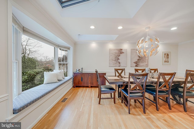 dining room with visible vents, a notable chandelier, a skylight, crown molding, and light wood finished floors