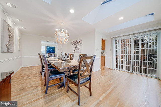 dining room featuring light wood-type flooring, recessed lighting, a skylight, crown molding, and a chandelier