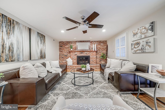 living area featuring recessed lighting, a brick fireplace, ceiling fan, and wood finished floors