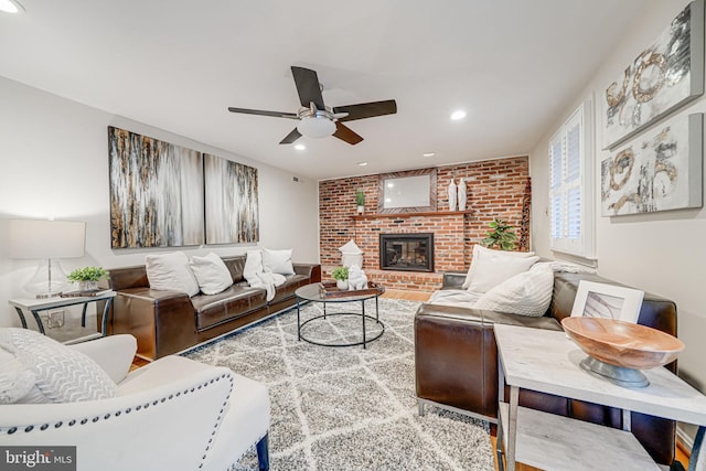 living room featuring recessed lighting, a brick fireplace, brick wall, and a ceiling fan