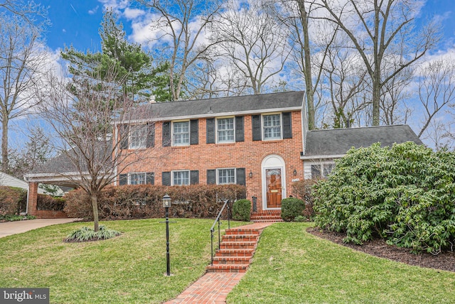 view of front of home featuring an attached carport, brick siding, concrete driveway, and a front lawn