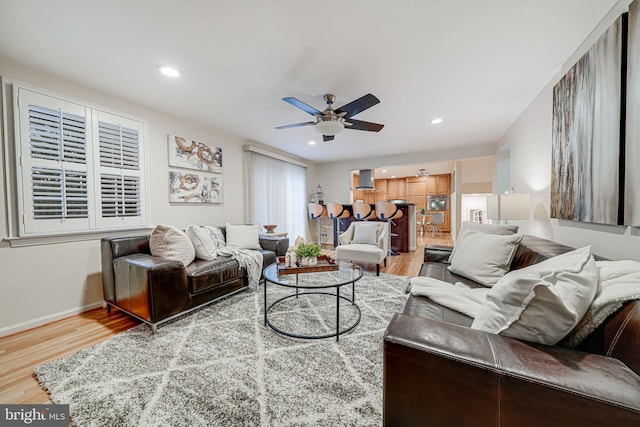 living room featuring a ceiling fan, recessed lighting, wood finished floors, and baseboards