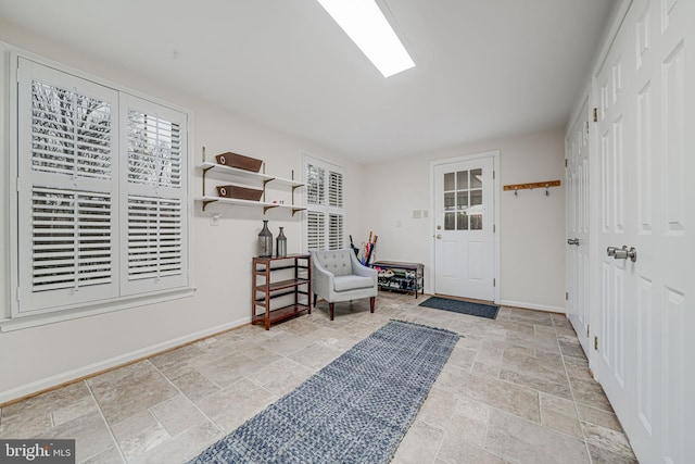 foyer with baseboards and stone finish floor