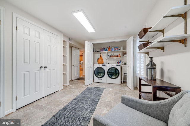 washroom with laundry area, stone finish flooring, and separate washer and dryer