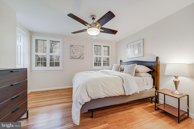 bedroom featuring baseboards, light wood finished floors, and ceiling fan