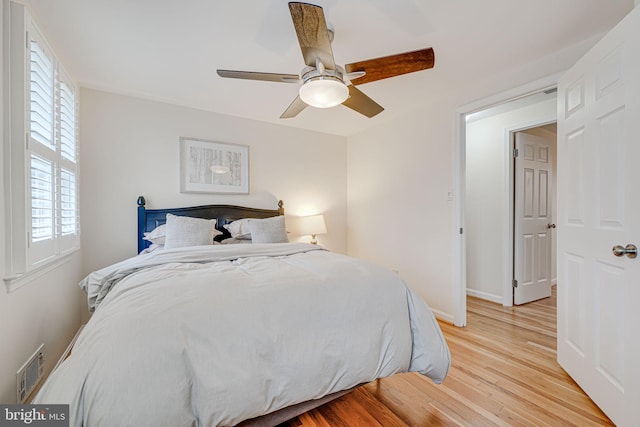 bedroom with visible vents, baseboards, a ceiling fan, and light wood finished floors