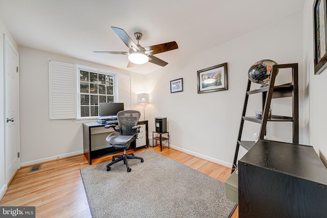 office featuring visible vents, light wood-style flooring, baseboards, and ceiling fan