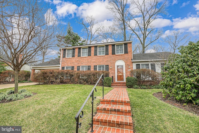 colonial house featuring a front yard and brick siding