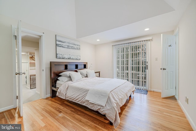 bedroom with recessed lighting, a high ceiling, light wood-type flooring, and baseboards