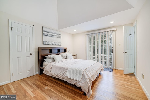 bedroom with recessed lighting, light wood-style flooring, baseboards, and access to outside