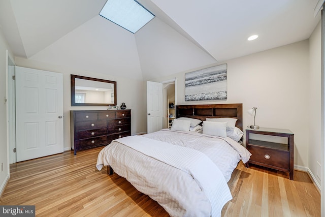 bedroom featuring recessed lighting, baseboards, vaulted ceiling with skylight, and light wood-style floors