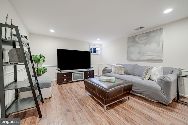 living room with recessed lighting, visible vents, and light wood finished floors