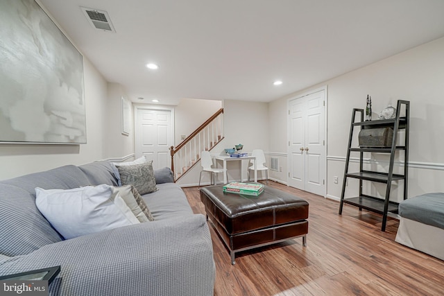 living room featuring recessed lighting, visible vents, wood finished floors, and stairway